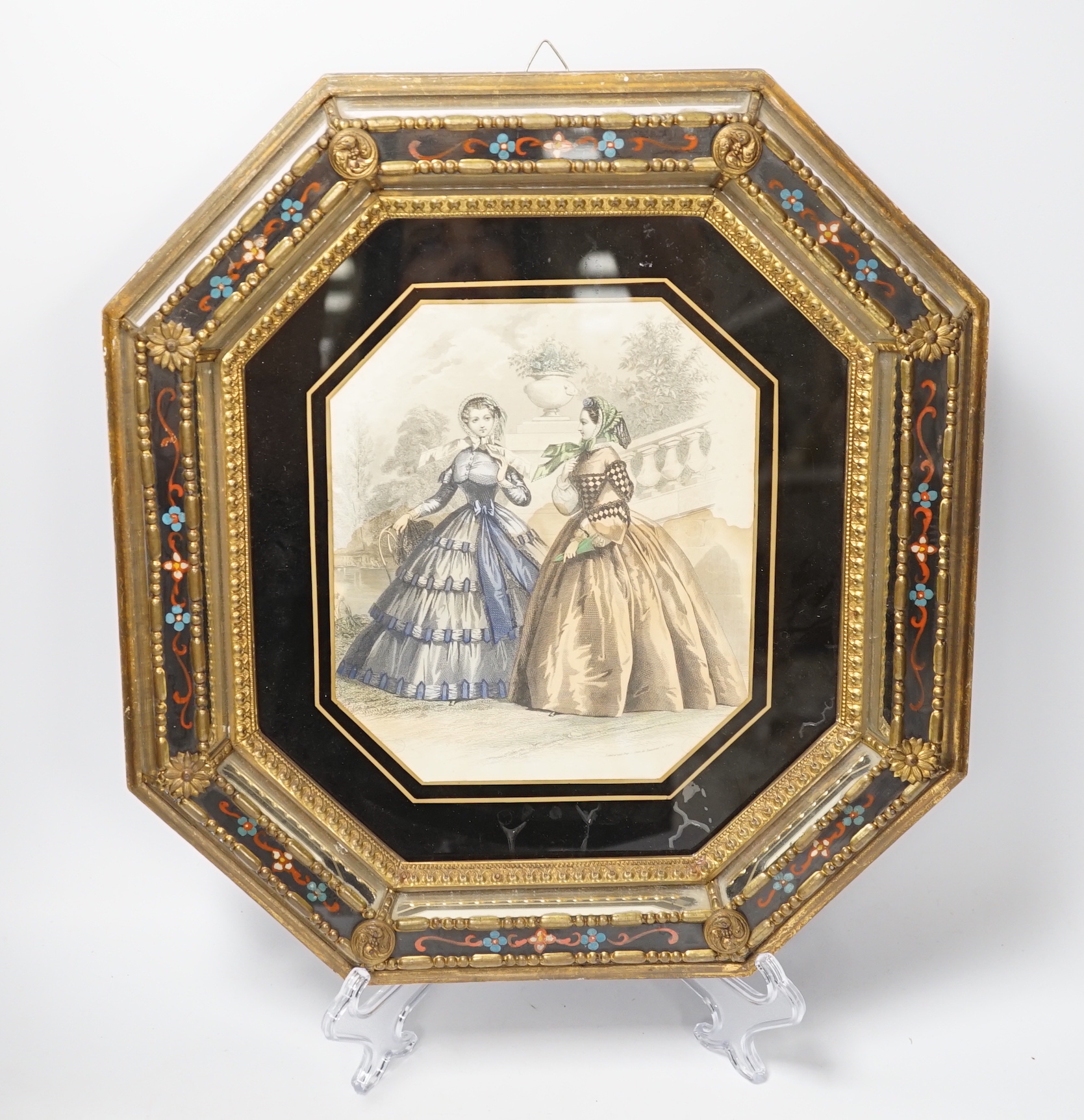 An octagonal embossed brass and verre eglomise mirrored frame, 36cm x 39cm